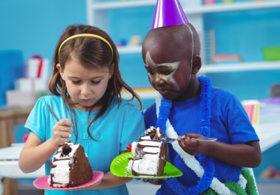 Happy kids eating birthday cake at the party